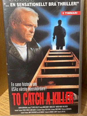To Catch a Killer VHS - En spännande VHS med titeln 'To Catch a Killer', baserad på en sann historia om en av USAs värsta massmördare. Omslaget är färgstarkt med röd och vit text, och motiv av trappor, siluetter och handbojor. Perfekt för dig som gillar nervkittlande berättelser.