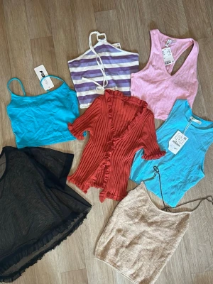 Topp - Ett paket på 7 toppar, och 4 av dem har fortfarande prislappen kvar. Den svarta är genomskinlig i mesh. Alla toppar är i storlek S förutom den ljusblå toppen med spaghetti straps som är i storlek XS. Märkena är: Zara, H&M, New Yorker, Pull & Bear.