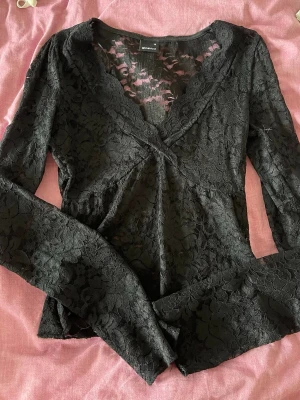 Svart spetströja från Gina Tricot - Säljer en svart långärmad spetsblus från Gina Tricot med v-ringning och fina spetsdetaljer. 