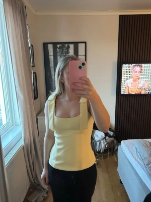 Gul topp från Zara - En gul topp med rosetter från Zara i storlek Xs och är i väldigt bra skick och använd fåtal gånger 