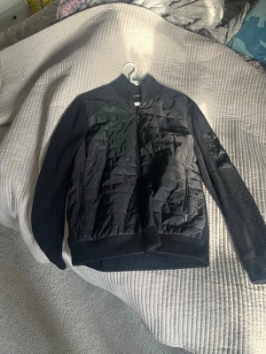 Svart bomberjacka från J.Lindeberg - Svart cardigan från J.Lindeberg! I bra skick och perfekt inför våren! Är i bra skick.