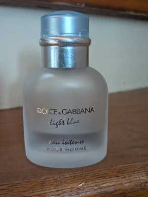 Dolce & Gabbana Light Blue Pour Homme - Fräsch parfym för män, Dolce & Gabbana Light Blue Pour Homme Eau Intense. Flaskan är frostad och har en rundad form med silverfärgad hals och ljusblå kork. Perfekt för dig som gillar en modern och stilren doft.