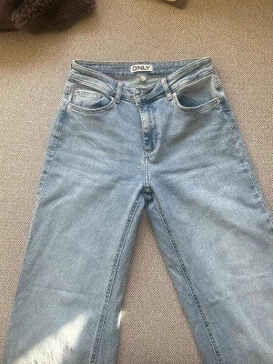 Ljusblå raka jeans från ONLY - Säljer ett par ljusblå jeans från ONLY med klassisk femficksmodell och raka ben. Jeansen har hög midja och är tillverkade i mjukt denimtyg.🩵