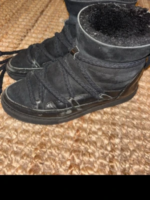 Svarta höga boots med snörning - Säljer ett par svarta boots med högt skaft och grov snörning runt hela skon. Utsidan är i mocka och detaljer i läder, insidan är fodrad med mjukt material. Snygg och unik design som sticker ut.