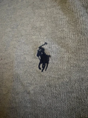 Grå stickad tröja från Polo Ralph Lauren - Tunn stickad tjocktröja, bra skick.                        Storleken är XL i barnstorlek som passar ungefär S. Tröjan är bara skrynklig. Går snabbt och sälja vidare för er som orkar hålla på.