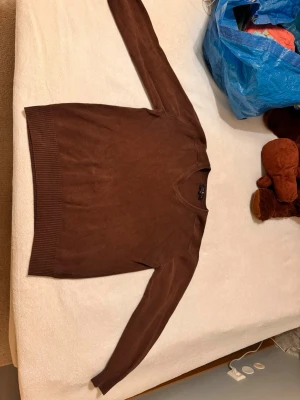 Stickad tröja - Säljer en fin stickad brun herrtröja. Den är lagad i armhålorna men det syns knappt när man har på sig den.