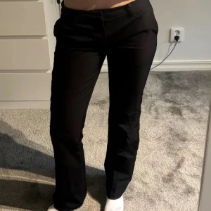 Svarta kostymbyxor från bikbok - Snygga svarta kostymbyxor med bootcut-snitt och normal passform. Byxorna har klassisk design med hällor för bälte och diskreta fickor. Perfekta för en stilren look och passar till många olika outfits.