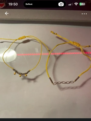 Gula armband med pärldetaljer - Två  armband med små silverfärgade pärlor och kedjedetaljer. Ena armbandet har även små gula pärlor som hänger ned. Justerbar knytning för perfekt passform. Perfekt accessoar för en färgglad och personlig stil. Max 26cm omkrets💛💛