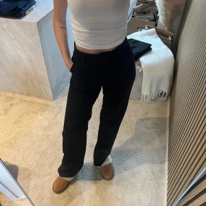 Svarta raka byxor från madlady  - Snygga svarta byxor med rak passform och hög midja. Byxorna är tillverkade i mjuk bomull och har en klassisk look som passar till många olika stilar. Perfekta att matcha med en enkel topp eller hoodie.