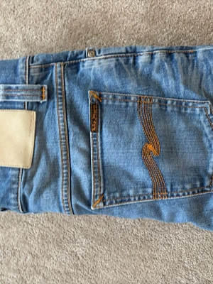 Nudie jeans grim Tim  - Säljer ett par Nudie Jeans Grim Tim i storlek W31 L32. Klassisk slim straight-modell som sitter riktigt snyggt. Jeansen är i bra skick och väldigt sköna att ha på sig. Passar till både vardag och lite mer uppklädda outfits.  Modell: Grim Tim Storlek: W31 L32 Skick: Bra skick Säljes: då de inte kommer till användning längre.