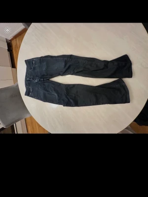 Mörkblå slim fit jeans - Snygga mörkblå slim fit jeans med klassisk femficksdesign och låg midja. Jeansen har smala ben och diskreta sömmar, perfekta för en trendig och avslappnad look.