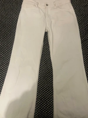 Vita raka jeans - Säljer ett par vita jeans med rak passform och rak modell . Jeansen har bälteshällor och stängs med knapp och dragkedja. Perfekta för dig som vill ha en clean och stilren look.