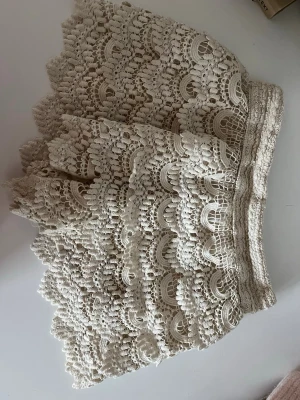 Beige spetsshorts med volang - Volang shorts med spets, är i storlek M men skulle säga att den är ungefär S/XS men väldigt stretchiga 💕