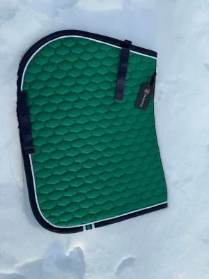 Grönt schabrak från Fairfield COB - Säljer ett grönt schabrak från Fairfield i storlek COB. Grönt med mörkblått kantband och vit detalj. Har praktiska kardborreband för enkel fastsättning.