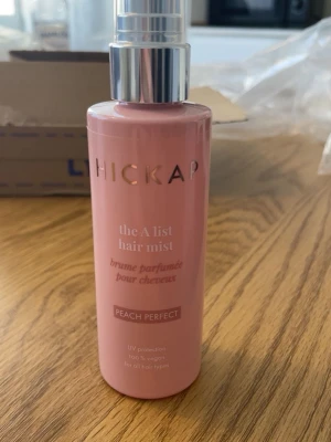 Hickap A List Hair Mist Peach Perfect - Säljer en rosa hårmist från Hickap, A List Hair Mist Peach Perfect. Flaskan innehåller 100 ml. Doft av persika och tropiska frukter, ger UV-skydd och passar alla hårtyper. 100% vegansk, helt ny