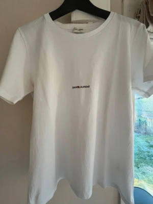 Vit Saint Laurent t-shirt - Vit t-shirt från Saint Laurent! Säljer du den inte kommer till användning längre, köpt för 2600kr på cettire