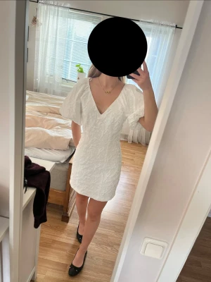 Vit klänning - Säljer en vit klänning med v-ringning och puffiga ärmar.  Denna är såå snygg och den är endast använd en gång på 9:ans skolavslutning. Storleken är 36 och passar de som vanligtvis har storlek S ungefär💓💓