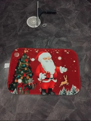 Julmatta med tomtemotiv - Röd rektangulär matta med tryck av jultomte, julgran, paket och ren. Perfekt som dekoration till julen. Mattan har färgglada detaljer och är tillverkad i mjukt syntetmaterial.40X60cm kanske behöver sig en tvätt dock. Finns fler jul saker på min sida