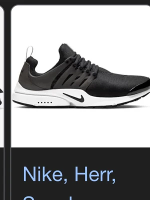 Nike Air Presto svarta sneakers - Svarta Nike Air Presto sneakers med vit sula och svart swoosh. Ovandelen är i mesh för bra andningsförmåga och har en plastbur för extra stöd. Skorna har elastiska snören och en låg profil som ger en sportig och clean look.