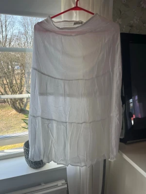 Vit volangkjol från Name It - Säljer en luftig vit kjol från Name It i storlek 164. Kjolen har flera volanger och är gjord i ett tunt, skrynkligt tyg som ger en avslappnad känsla. Perfekt för varma dagar och enkel att matcha med olika toppar.