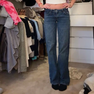 Blå raka jeans med låg midja - Snygga blå jeans med rak passform och hög midja. Klassisk femficksmodell och normal längd. Perfekta för en avslappnad och trendig stil. Jeansen har en tidlös tvätt och passar till det mesta.