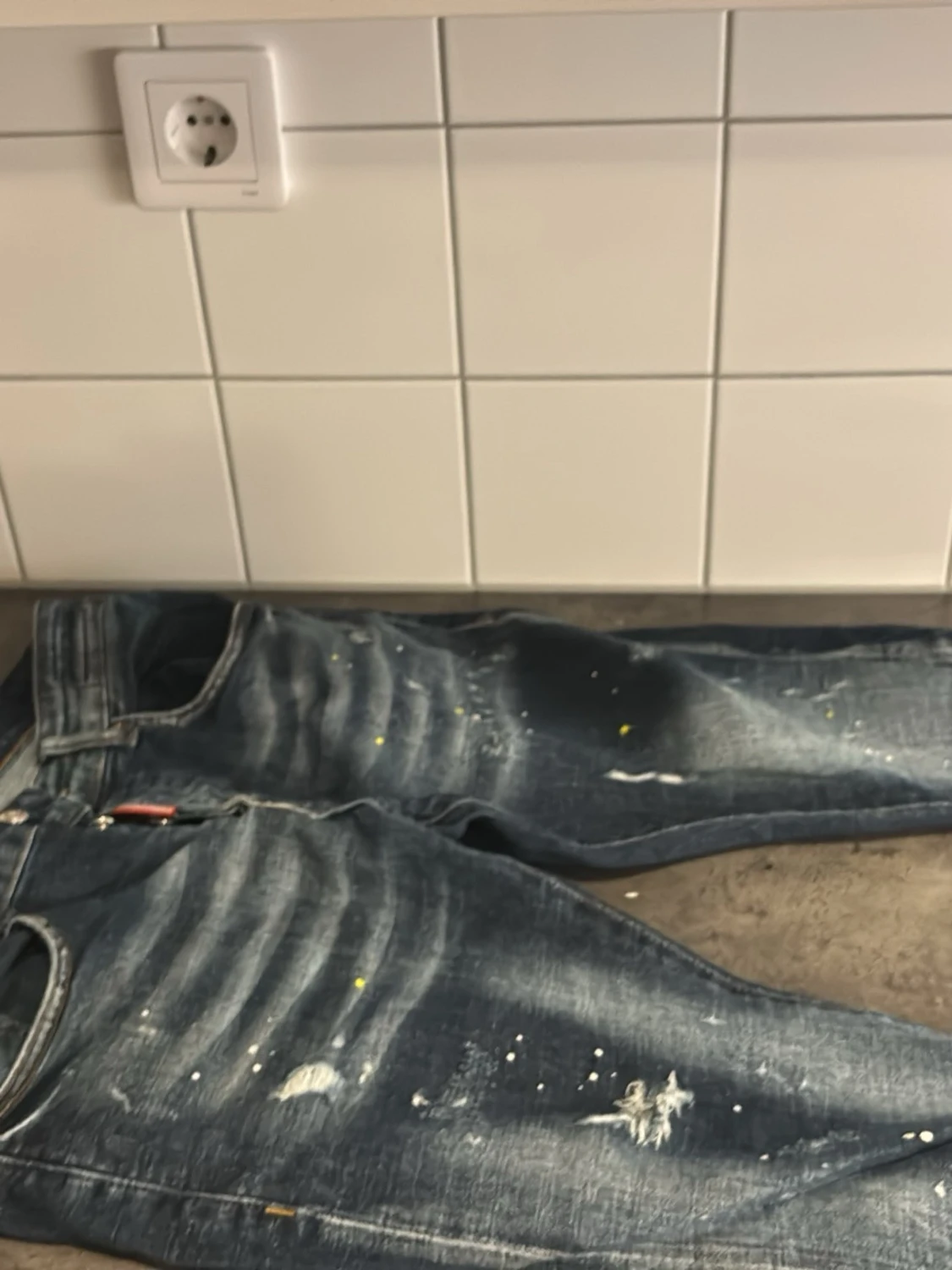 Blå slitna jeans med färgstänk