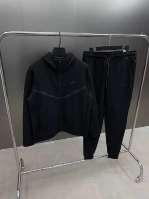 Svarta Nike Tech Fleece full set! - Säljer ett par svarta Nike Tech Fleece mjukisbyxor med matchande hoodie. Byxorna har dragsko i midjan och smal passform. Hoodien har dragkedja, fickor och en snygg detalj på ärmen. Perfekt för chill dagar eller när du vill vara bekväm och stilren. Pris kan diskuteras!