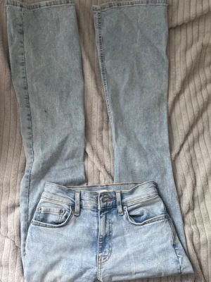 Ljusblå jeans Gina - Ljusblå midwaist jeans från Gina, "Perfect Jeans" heter de men kan inte hitta de på Ginas hemsida tyvärr. Storlek 32 och passar mig bra i längd som är 159cm. Utsvängda ben. Kanske använd nån gång men dessa har mest legat oanvända.