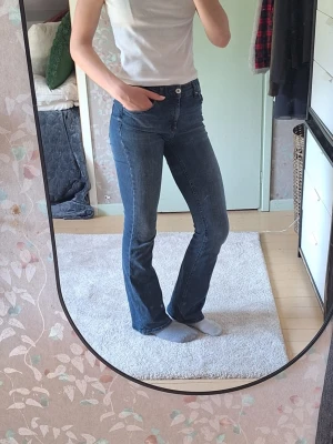 Blå bootcut jeans med medium waist - Säljer ett par blå bootcut jeans med medium waist och klassiska fem fickor.💕 Jeansen har en snygg tvätt och sitter tajt över låren för att sedan bli vidare nedtill. Perfekta till sneakers eller boots och ger en retrovibe till outfiten. Otroligt sköna. 