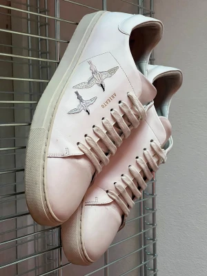 Vita sneakers från Axel Arigato - Snygga vita sneakers från Axel Arigato med broderade fåglar på sidan. Använda ett fåtal gånger. 