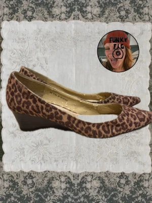 Leopardmönstrade pumps med kilklack - Säljer ett par snygga pumps med leopardmönster och kilklack. Skorna har spetsig tå och är klädda i ett tyg med brunt och svart mönster. Perfekta för dig som vill sticka ut med din stil. Som ni ser är skon väldigt sliten inuti , men inget som syns när man har på sig dem! 
