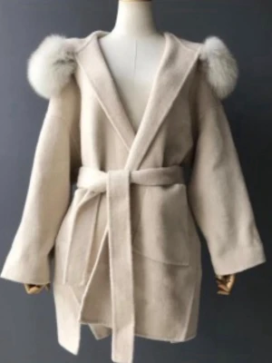 Ull/kashmir pälskappa från Vivanilla - Äkta ullrock med rävpälsdekoration. Stor päls och en linning för en smalare passform. Alla pälsdetaljer kan tas bort. Oversized modell så passar upp till storlek S. Kappan är en blandning av ull och kashmir så den är mycket varm och skön! Mycket fint skick och som ny.  färg:beige  tvättråd:kemtvätt  Storlek: XS  Nypris: 3039kr, mitt pris: 1999kr