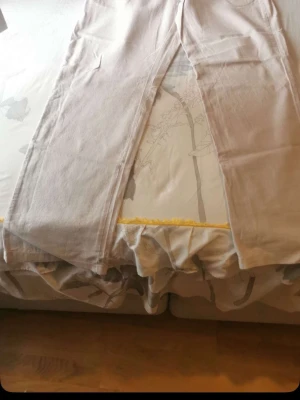 Beiga vida linnebyxor - Säljer ett par beiga linnebyxor med raka, vida ben och hög midja. Byxorna har en enkel och stilren design utan synliga detaljer eller mönster. Perfekta för en avslappnad och trendig look under varmare dagar.