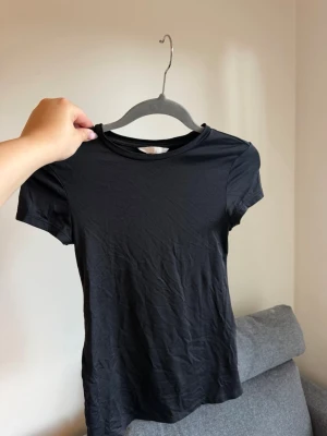 Svart basic t-shirt i bomull - En enkel svart t-shirt med en thight passform.