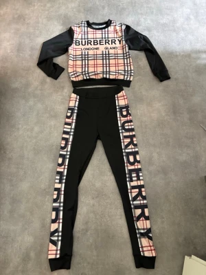 2-delat set. Tröja och byxor/legging  - 2-delat set med tröja och byxor/leggings. Med mönster och test på. Text och mönster på tröjan, baksidan är svart. Hela setet är i storlek S. Aldrig använt!