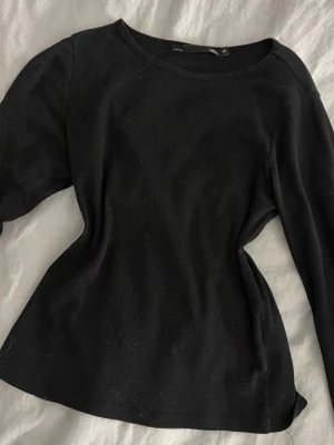 Svart långärmad topp i bomull - En enkel svart långärmad topp från H&M i mjuk bomull. Modellen har rund halsringning och normal passform, perfekt att styla med jeans eller kjol. Klassisk och tidlös design som funkar till många olika looks.