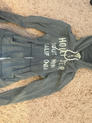Grå hollister hoodie - Grå hollister hoodie säljer eftersom den inte kommer till någon användning längre och är i mycket bra skicka vill helst bli av med så snabbt som möjligt❤️‍🩹