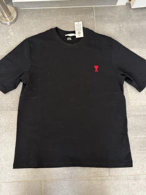 Svart t-shirt från Ami Paris - Stilren svart t-shirt från Ami Paris med klassisk passform och rund hals. Pisk kan diskuteras 