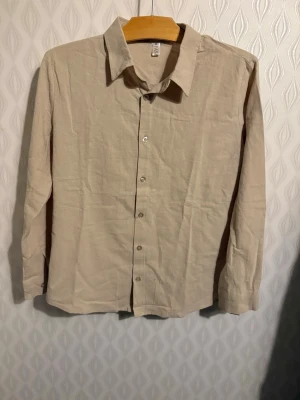 Beige linneskjorta med knappar. - Passar som small.