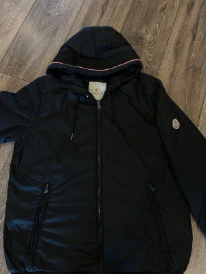 M0ncler jacka - En riktigt snygg m0ncler jacka som är svart och perfekt inför höst/ vinter. Det är en down jacka som kommer hålla dig varm med stora fickor och även ficka på insidan. Jackan är för stor för mig då det är en storlek M. (Jag är 170 57~kg). Jag hade på mig jackan i slutet av vintras men tyckte den var för stor och slutade använda den efter ungefär 5-7 gånger. Perfekt för dig som är 175-185. Går att förhandla priset, gör även byten.