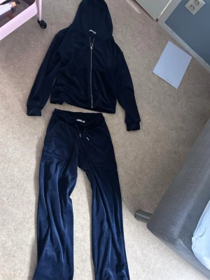 Mörkblå velour loungewear-set - Mysigt loungewear-set i mörkblå velour med hoodie och dragkedja samt matchande byxor med dragsko i midjan. Perfekt för chill dagar hemma. Setet har en mjuk känsla och avslappnad passform.