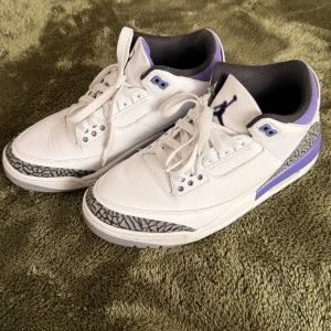  Jordan 3 court purple - Box medföljer och Kvitto finns. Säljer ett par vita Air Jordan 3 sneakers med lila och svarta detaljer. Skorna har klassiskt elefantmönster vid tån och hälen, samt lila inslag på häl och snörhål. Tillverkade i läder med textilfoder och gummisula. Perfekta för dig som gillar retrostil och streetwear.
