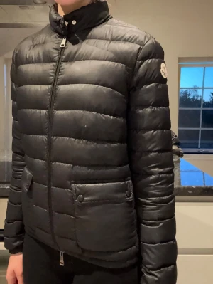 Svart dunjacka från Moncler - Säljer nu min fina Moncler jacka eftersom jag vuxit ur den. Den är i fint skick men har lite defekter som man inte tänker på (Se bilder). Kartong och klädpåse ingår ifrån Moncler. Köpt för 8000 kr säljer för 2500 kr kom gärna med bud. Kan gå ner i pris vid snabb affär. ☺️Vid fler frågor kontakta gärna mig. 😊Storlek: 1 / S 