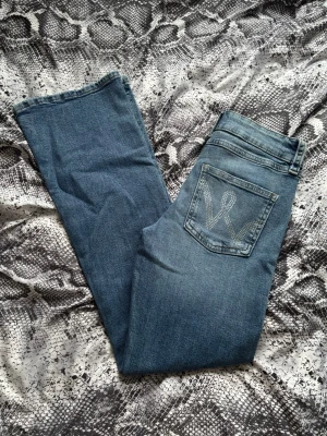 Lågmidjade bootcut jeans  - Säljer ett par lågmidjade bootcut jeans från Gina Tricot med rhinstone detaljer på bakfickorna. Jeansen är tillverkade i mjukt denimtyg. Perfekta för dig som gillar retrostil och vill ha ett par jeans med snygg passform. Jag har aldrig använt dom så dom är i nyskick! Dom är väldigt lika Wrangler jeans, dom verkar även vara slutsålda då jag inte kunde hitta dem eller liknande någonstans🥰