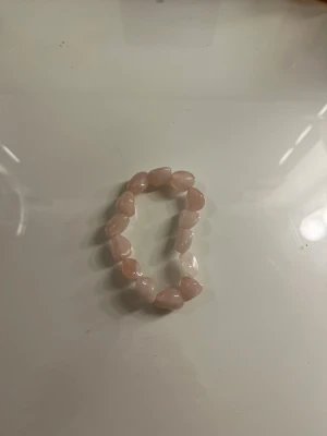 Elastisk armband med rosenkvartspärlor - Snyggt armband med stora, oregelbundna rosenkvarts pärlor i ljusrosa ton. Pärlorna har en glansig yta och sitter på elastisk tråd, vilket gör det enkelt att ta på och av. Perfekt accessoar för dig som gillar en mjuk och feminin stil.