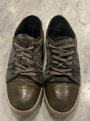 Gråa gröna Lanvins  - Snygga sneakers från lanvin  i grå mocka med gröna detaljer i läder på tån och runt snörningen. Skorna har vita sulor och gråa skosnören. Perfekta för dig som gillar en stilren men unik look.
