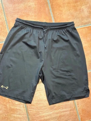 Zlatan A-Z Träningsshorts - Zlatan träningsmärke A–Z, barnstorlek 152/164 (XXS) Mycket bra material att träna i. Mycket bra skick, förutom det som syns på sista bilden.  Zlatan training gear A–Z, kids size 152/164. (XXS) Great material for training. Very good condition, except for what’s shown in the last picture.