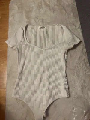 Vit ribbad body med v-ringning - Vit ribbad body med fin u-ringning💗