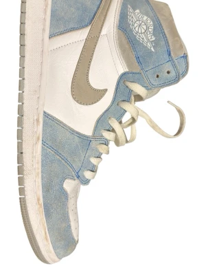 Air Jordan 1 High University Blue - Snygga Air Jordan 1 High sneakers i vitt och ljusblått med gråa detaljer och swoosh. Ovandelen är i en mix av mocka och läder, med klassisk Air Jordan-logga på sidan. Tjock vit sula och högt skaft för ikonisk look.