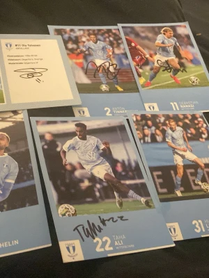 Signerade Malmö FF spelarkort - Samling med signerade spelarkort från Malmö FF, inklusive spelare som Ola Toivonen, Anton Tinnerholm, Sebastian Nanasi, Taha Ali, Hugo Larsson och Isaac Kiese Thelin. Korten har foton på spelarna i ljusblå matchställ och autografer på framsidan. Perfekt för fotbollsfans och samlare. Jag kan tänka mig att sänka priser några hundra lappar.